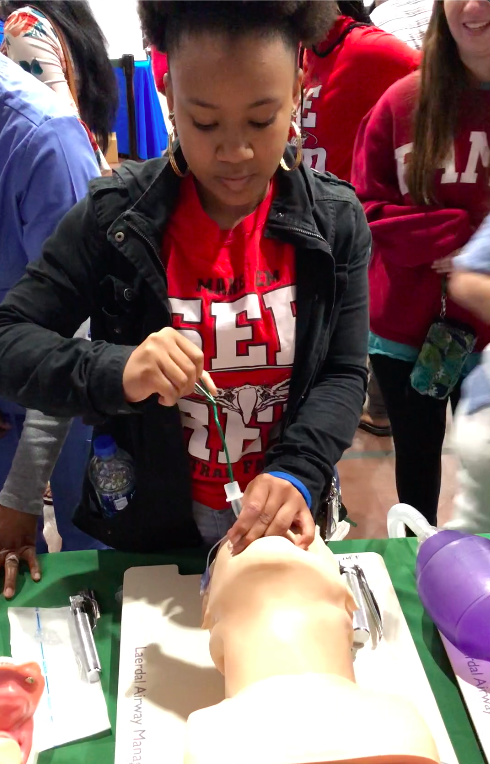 high school female operating on dummy