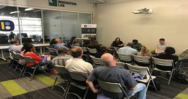 Central Six Meeting with people sitting in chairs in a room