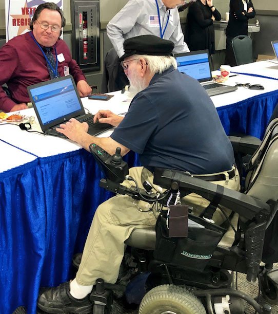 man in wheelchair using computer